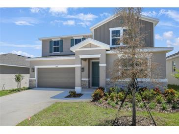 Beautiful two-story home with attached two car garage and manicured front lawn at 1698 Sugarbelle Cir, Mascotte, FL 34753