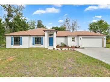 Charming single-story home with white exterior, brown roof, blue shutters and well-manicured lawn at 314 Dagama Ct, Kissimmee, FL 34758
