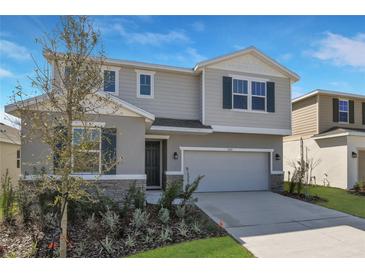 Two-story home featuring a two-car garage, neutral siding, and a well-manicured lawn at 5414 Catmint Dr, Lake Hamilton, FL 33851