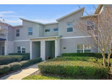 Modern two-story townhome with gray exterior, landscaping, and walkway at 890 Pebble Beach Dr, Davenport, FL 33896