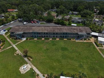 Aerial view of a well-maintained condominium complex with lush green lawns and mature trees at 1600 W Lake Parker Dr # B23, Lakeland, FL 33805