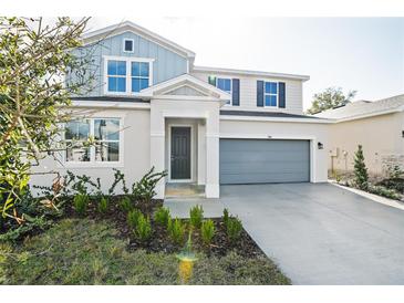 Two-story home with gray and blue exterior, two-car garage, and landscaping at 1740 Carnelian St, Deland, FL 32720