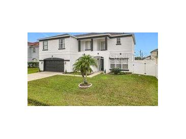 Two-story house with white exterior, black accents, and a two-car garage at 269 Beckenham Dr, Kissimmee, FL 34758