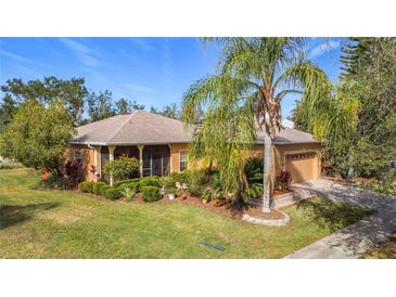 Single-story house with landscaped yard, screened porch, and attached garage at 512 Heartwell Dr, Poinciana, FL 34759