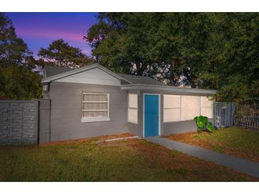 Updated bungalow exterior with gray siding, blue door, and landscaped yard at 907 Columbia St, Orlando, FL 32805