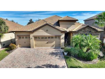 Attractive two-story house with a tile roof, two-car garage, and landscaped yard at 1311 Moss Creek Ln, Davenport, FL 33836