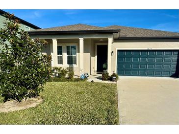 Single-story house with dark green garage door and well-manicured lawn at 1625 Hill Park Dr, Deltona, FL 32725