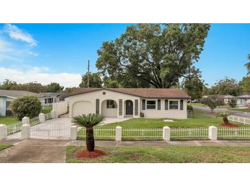 Updated single story home with a large front yard, driveway, and white picket fence at 4401 Marshall St, Orlando, FL 32811