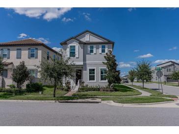 Two-story house with gray siding, white trim, and a landscaped front yard at 10415 Austrina Oak Loop, Winter Garden, FL 34787