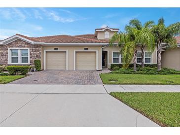 Two-car garage, attractive landscaping, and a brick facade at 1066 Quaker Ridge Ln, Davenport, FL 33896