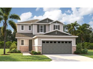 Two-story house with gray siding, stone accents, and a three-car garage at 219 Bull Frog Ln, Umatilla, FL 32784