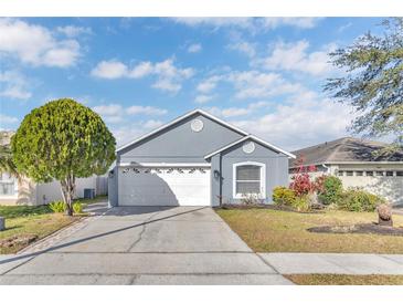 Gray house with white garage door and landscaping at 7761 Fort Mchenry Ct, Orlando, FL 32822