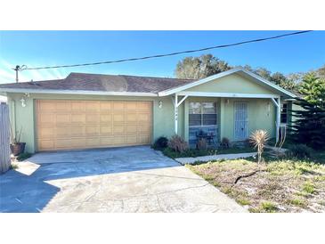 Light green single story house with attached garage and small front yard at 1592 Martin Luther King Ne Blvd, Winter Haven, FL 33881