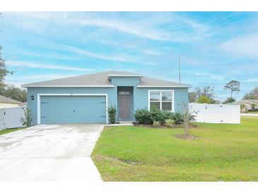 One-story house with blue exterior, two-car garage, and landscaped yard at 233 Tiffany Ct, Kissimmee, FL 34758