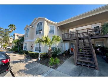 Exterior view of condo building with parking and landscaping at 2332 Prime Cir # B, Kissimmee, FL 34746