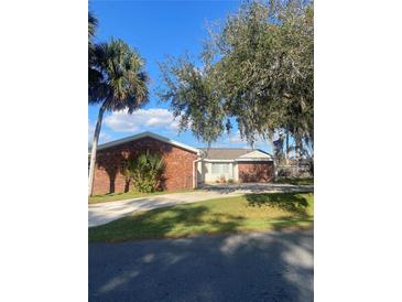 Brick house with a landscaped yard and driveway at 2681 Robin Ave, Kissimmee, FL 34744