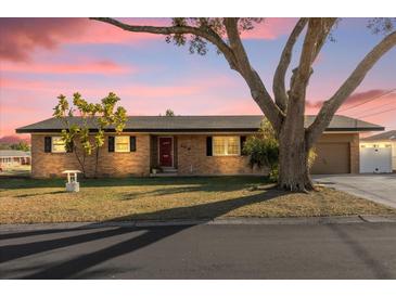 Brick ranch house with a large tree and attached garage at 306 Boger N Blvd, Lakeland, FL 33803