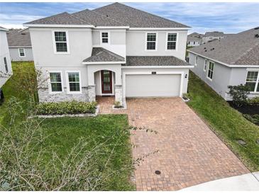 Two-story house with gray siding, stone accents, and a brick driveway at 5052 Center Ct, St Cloud, FL 34772