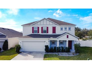 Two-story house with gray siding, red shutters, and a two-car garage at 524 Sardinia Cir, Davenport, FL 33837