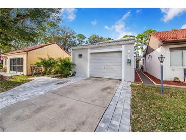 Front view of a house with a driveway and garage at 103 Las Flores, Winter Haven, FL 33884