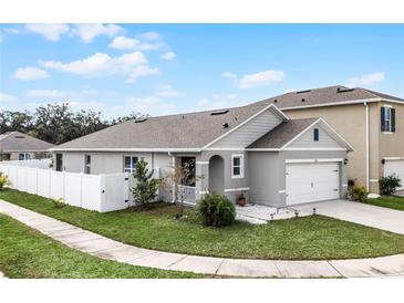 Gray house with white fence and landscaping at 1956 Egret Meadows Ave, Kissimmee, FL 34744