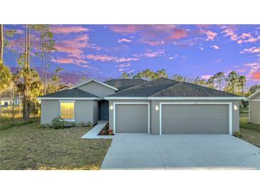 New construction home with two-car garage and landscaped lawn at 22 Peterlee Ct, Kissimmee, FL 34758