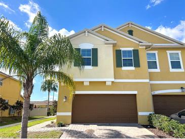Inviting two-story home with a well-maintained lawn, lush palm tree, and a spacious two-car garage at 272 Muscogee Ln, Orlando, FL 32825