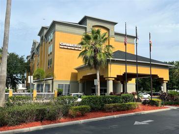 Hotel exterior featuring a multi-story building with ample parking at 3000 Maingate Ln # 228, Kissimmee, FL 34747