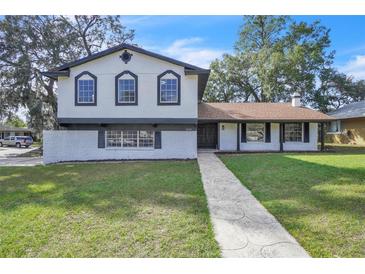Two-story home with a well-manicured front yard and a patterned walkway leading to the front door at 3020 Rockingham Cir, Orlando, FL 32808