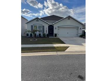 One-story home with two-car garage, landscaping, and a neutral color palette at 3309 Sonder Dr, Davenport, FL 33896
