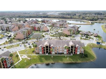 Aerial view of apartment community by lake with green space at 4105 Tropical Isle Blvd # 216, Kissimmee, FL 34741