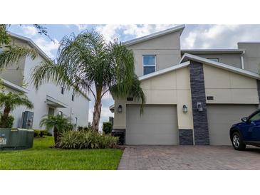 Modern two-story home with attached two-car garage and landscaping at 701 Ocean Course Ave, Davenport, FL 33896