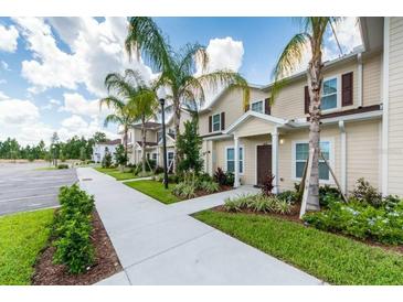 Exterior view of townhouses with landscaping and walkway at 8906 Shine Dr, Kissimmee, FL 34747