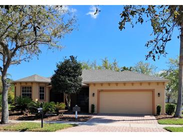 Charming single-story home featuring a two-car garage and well-manicured landscaping and a brick paver driveway at 900 Shorehaven Drive, Poinciana, FL 34759