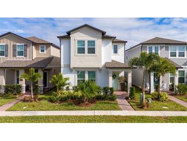 Two-story home with light-colored siding, landscaping, and a paved walkway at 12549 Encore At Ovation Way, Winter Garden, FL 34787