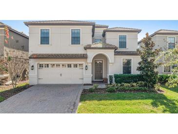 Two-story house with a three-car garage and landscaped lawn at 1455 Rolling Fairway Dr, Davenport, FL 33896