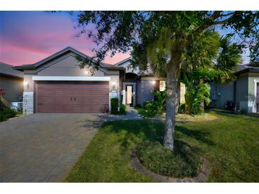 Inviting home exterior featuring a brown garage door and landscaped yard at 217 Montoro Ln, Davenport, FL 33837