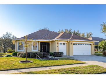 Charming single-story home with a well-manicured lawn, lush landscaping, and a spacious three-car garage at 26622 Bull Run, Leesburg, FL 34748