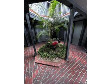 Ground level view of a courtyard with brick flooring and tropical plants at 3984 Atrium Dr # 4, Orlando, FL 32822