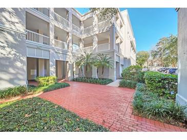 Brick walkway leads to a 3-story building with balconies and lush landscaping at 651 Celebration Ave # 651, Celebration, FL 34747