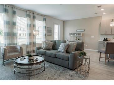 Bright living room features a comfy sofa and large windows at 800 Benoi Dr, Davenport, FL 33896