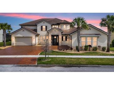 Two-story house with brown tile roof, stone accents, and a three-car garage at 820 Windlass Ct, Kissimmee, FL 34746
