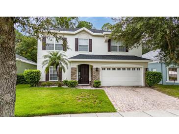 Two-story house with stone accents, a two-car garage, and a well-manicured lawn at 1007 Crane Crest Way, Orlando, FL 32825