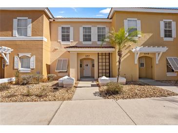 Front view of a two-story tan building with white shutters and landscaping at 1017 Park Ridge Cir, Kissimmee, FL 34746