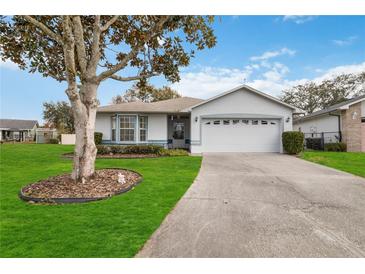 Single-story home with a two-car garage and well-manicured lawn at 1403 Sean Ct, St Cloud, FL 34772