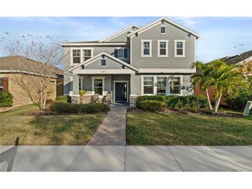 Two-story house with gray siding, stone accents, and a landscaped lawn at 1493 Reflection Cv, St Cloud, FL 34771