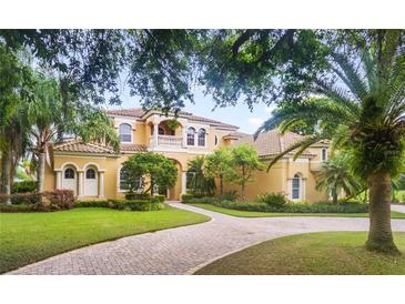 Two-story house with tile roof, manicured lawn, and circular driveway at 1515 Sunset Pointe Pl, Kissimmee, FL 34744