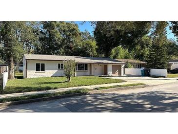 Charming single-story home features a well-maintained lawn and a paved driveway leading to an attached garage at 2009 S Osceola Ave, Orlando, FL 32806
