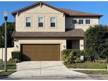 Inviting two-story home featuring a well-manicured lawn, brown accents, and an attached two-car garage at 2211 Bittle Way, St Cloud, FL 34769