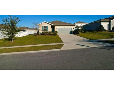 Charming single-story home with a well-maintained lawn, tidy landscaping, and an attached two-car garage at 2587 Summer Star Way, Leesburg, FL 34748
